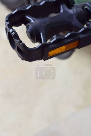 Téléchargez les photos : Un gros plan vertical de la pédale noire d'un vélo sur fond flou - en image libre de droit