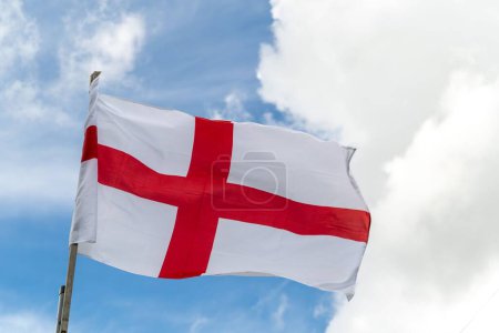 Téléchargez les photos : Le drapeau de l'Angleterre sur un beau fond bleu ciel nuageux - en image libre de droit
