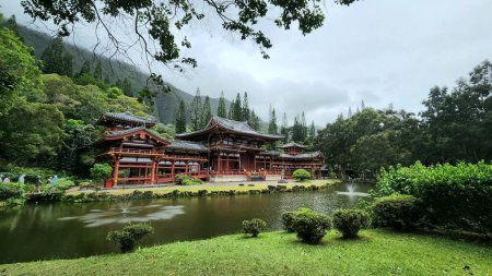 Photo for A landscape of the historic Byodo-In Temple on the background of a forested hill - Royalty Free Image