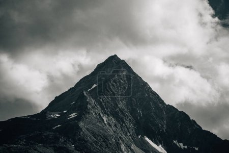Téléchargez les photos : Échelle de gris d'une montagne crantée contre un ciel nuageux - en image libre de droit