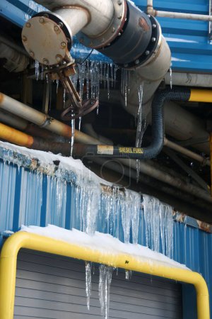 Photo for A vertical closeup shot of frozen icicles hanging on industrial pipes - Royalty Free Image