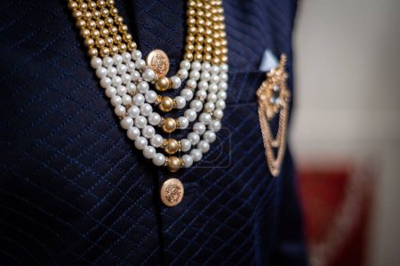 Téléchargez les photos : Un focus sélectif de bijoux dorés et une broche sur le costume de l'homme - en image libre de droit