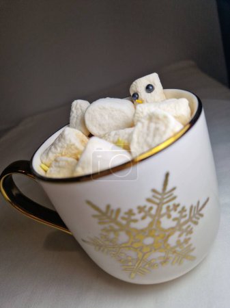 Téléchargez les photos : Un plan vertical de chocolat chaud avec des guimauves bonhomme de neige dans une tasse avec un flocon de neige - en image libre de droit
