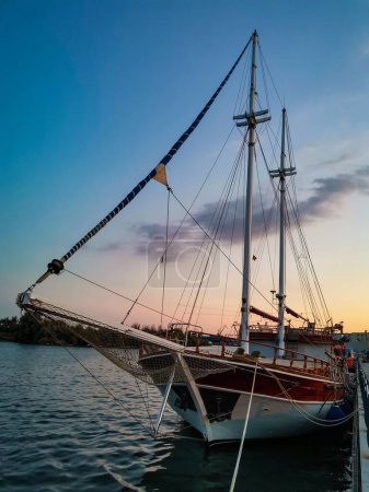 Téléchargez les photos : Plan vertical d'un voilier sur fond de coucher de soleil - en image libre de droit