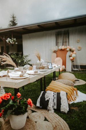 Téléchargez les photos : Un plan vertical d'une table de style Boho servi dans un jardin pour la fête de mariage - en image libre de droit