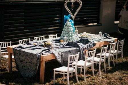 Foto de La mesa con una croquembouche en ella y sillas blancas preparadas para una ceremonia de boda - Imagen libre de derechos