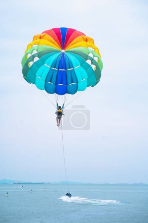 Photo for A man parasailing near the coast of the sea, vertical shot - Royalty Free Image
