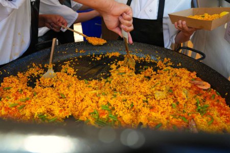 Photo for A close-up shot of people cooking paella in a street market - Royalty Free Image