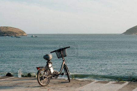 Photo for A small bicycle parked on the beach near the sea - Royalty Free Image