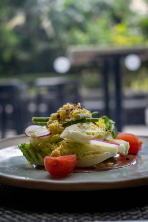 Photo for A vertical shot of a salad with iceberg lettuce cherry tomatoes and on a plate - Royalty Free Image