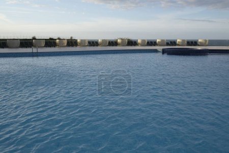Téléchargez les photos : La vue d'une piscine avec des chaises pliantes vides autour de Nicosie - en image libre de droit