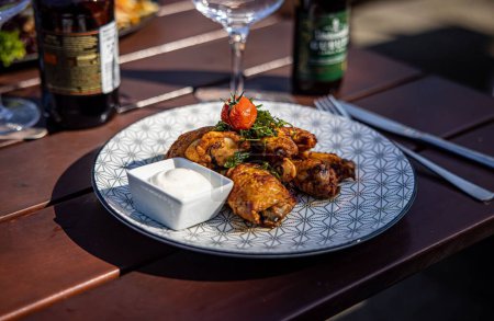 Téléchargez les photos : Plan rapproché d'un plat principal avec poulet et tomate rôtie sur une table dressée dans un restaurant - en image libre de droit