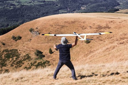 Téléchargez les photos : Un gros plan d'un homme lance un planeur modèle radiocommandé lors d'une compétition de modélisation d'avion - en image libre de droit