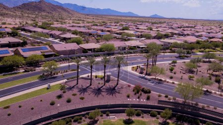 An aerial view of Goodyear, Arizona city with clean asphalt roads, low buildings and green trees
