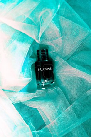 Photo for A vertical flat lay of Dior Sauvage Cologne against the teal fabric - Royalty Free Image