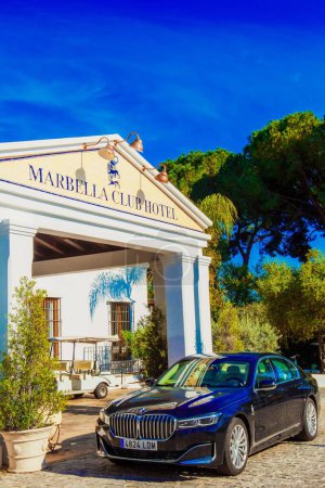 Foto de Un plano vertical de un coche BMW 7 de lujo aparcado cerca de la entrada del hotel Marbella club. España - Imagen libre de derechos