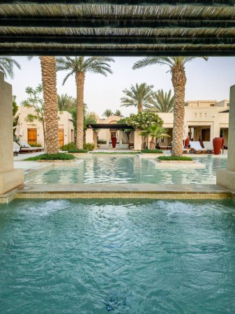 Téléchargez les photos : La vaste piscine à débordement avec palmiers et cabanes au Al Wathba Desert Resort and Spa - en image libre de droit