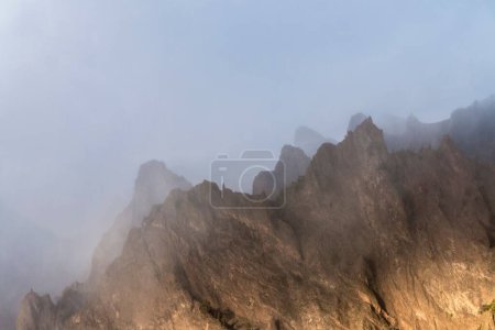 Téléchargez les photos : Une vue pittoresque sur les montagnes rocheuses couvertes de brouillard - en image libre de droit