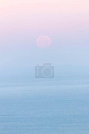 Téléchargez les photos : Un plan vertical du ciel bleu clair et rose avec la lune légèrement visible tôt le matin - en image libre de droit
