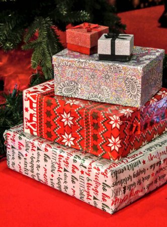 Photo for A vertical shot of the Christmas gifts with beautiful packing under the Christmas tree - Royalty Free Image