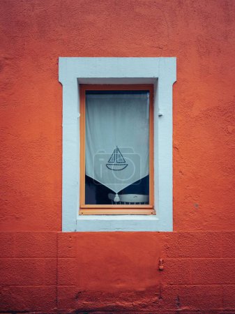 Foto de Un plano vertical de una ventana blanca de un edificio naranja con un barco en una cortina en Nantes, Francia - Imagen libre de derechos