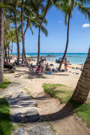 Téléchargez les photos : Les gens profitent d'une journée ensoleillée à Waikiki Beach, une destination touristique populaire à Honolulu, Hawaï. - en image libre de droit