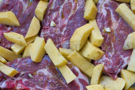 Photo for Homemade food, steaks with fries ready to go in the oven. Ingredients pork steak, potatoes, salt, oil, butter, oregano and pepper - Royalty Free Image