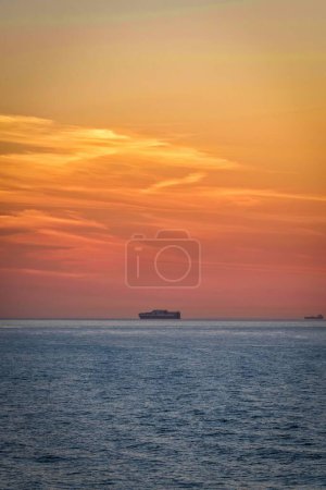 Photo for A vertical shot of a beautiful seascape and ships on water at scenic sunset in the English Channel - Royalty Free Image