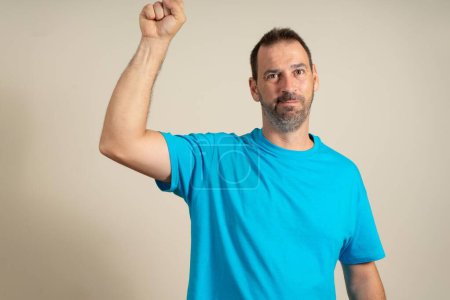 Photo for A man in a blue t-shirt showing up with a finger - Royalty Free Image