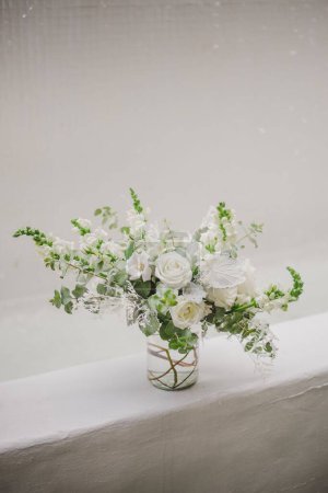 Photo for A vertical shot of a bouquet of white flowers in a vase on a white background - Royalty Free Image