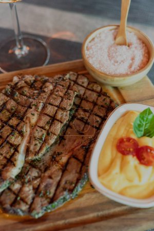 Photo for A vertical shot of a tasty steak prepared in the ambient of a high class elite steak house restaurant - Royalty Free Image