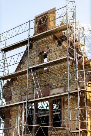 Photo for A vertical shot of an old masonry building covered in scaffolding - Royalty Free Image