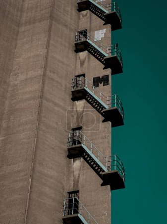 Foto de Un plano vertical de un edificio industrial alto con escaleras de escape de incendios en Rotterdam - Imagen libre de derechos