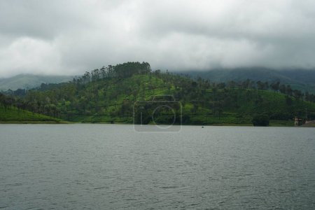 Téléchargez les photos : Un lac près d'une colline verdoyante avec des arbres - en image libre de droit