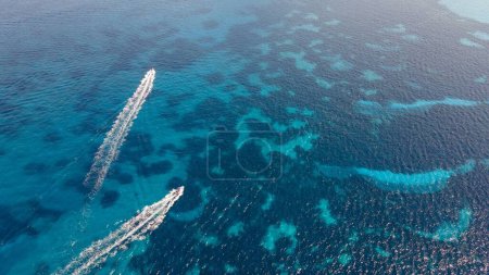 Photo for An aerial of two motor boats drawing water trails on a beautiful turquoise seascape - Royalty Free Image