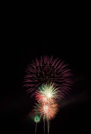 Téléchargez les photos : Un coup vertical de fusées explosant dans le ciel nocturne le 4 juillet. - en image libre de droit