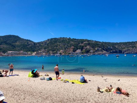 Téléchargez les photos : Une journée ensoleillée à Cala Formentor plage et les gens en vacances passer du temps et bronzer - en image libre de droit