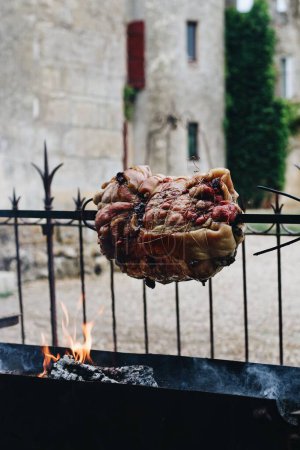 Photo for A closeup shot of roasting meat on a spit with fire on the background. - Royalty Free Image