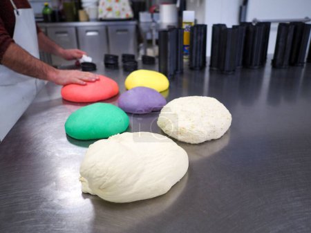 Téléchargez les photos : Chef boulanger faire rouge violet jaune et vert petits pains colorés de 30 grammes pour la nourriture événement doigt préparation traiteur - en image libre de droit
