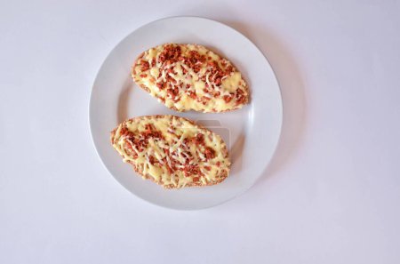 Photo for A top view of a toast with ground meat and cheese on a plate - Royalty Free Image
