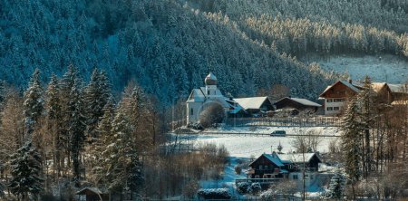 Téléchargez les photos : La Kapelle St. Nikolaus devant une pente couverte d'arbres lors d'une journée d'hiver à Fussen - en image libre de droit