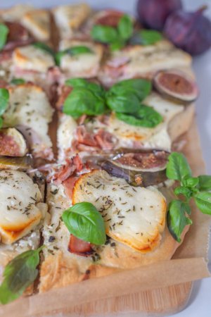 Téléchargez les photos : Une délicieuse pizza juteuse avec figues, bacon, cuit au four, boeuf et fromage sur fond bois, plan vertical - en image libre de droit