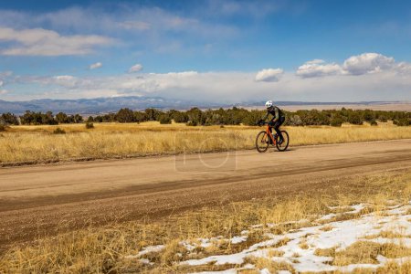 Téléchargez les photos : Cycliste le long d'un chemin de terre et prairie - en image libre de droit