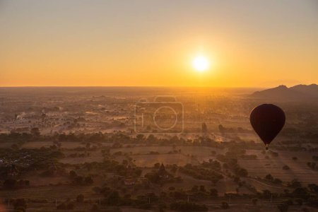 Photo for A hot air balloon floats over the Bagan plains in Myanmar (Burma) during sunrise. - Royalty Free Image