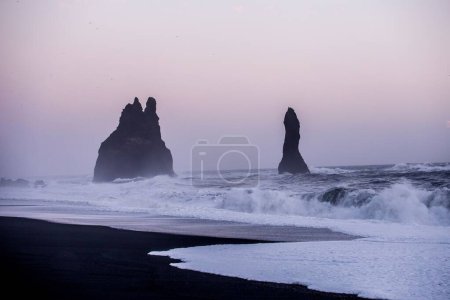 Foto de El mar de basalto se acumula bajo la montaña Reynisfjall cerca del pueblo de Vik, al sur de Islandia - Imagen libre de derechos