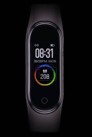 Foto de Una vista vertical de la pantalla digital de una pulsera de reloj inteligente negro antes de un fondo oscuro - Imagen libre de derechos