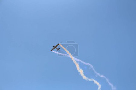 Photo for A low angle shot of a RC airplane flying in a cloudless blue sky - Royalty Free Image