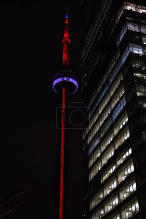 Photo for A vertical low angle of the CV tower and a skyscraper in Toronto Canada at night - Royalty Free Image