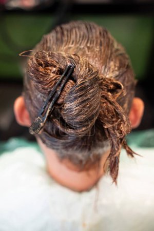 Téléchargez les photos : Un plan vertical de cheveux teints à la femme brune fixé avec un clip - en image libre de droit