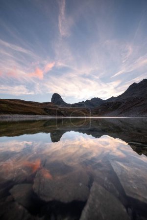 Téléchargez les photos : Un plan vertical d'un beau lac reflétant le ciel nuageux avec des montagnes en arrière-plan - en image libre de droit